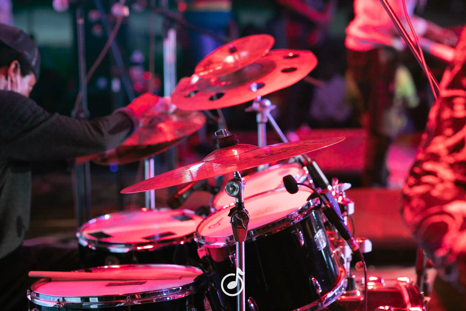 Drummer performing under deep red lighting during a Livemusic Studios production