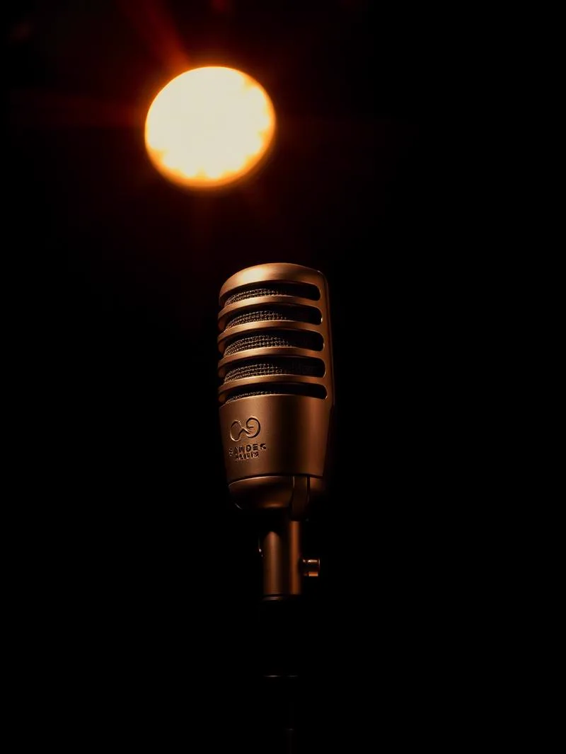 Studio microphone under a single warm spotlight